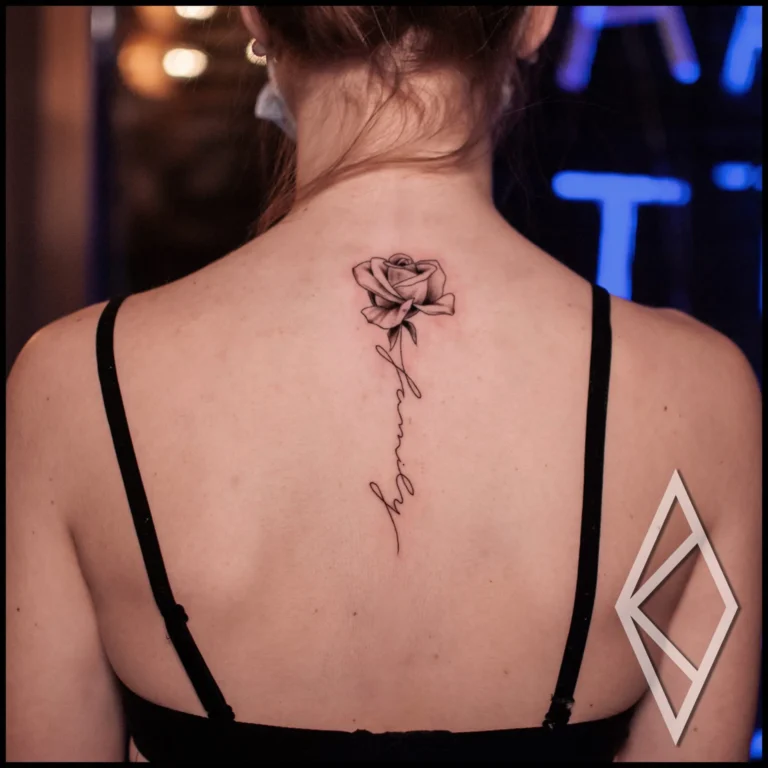 Beautiful fineline flower tattoo on woman's back