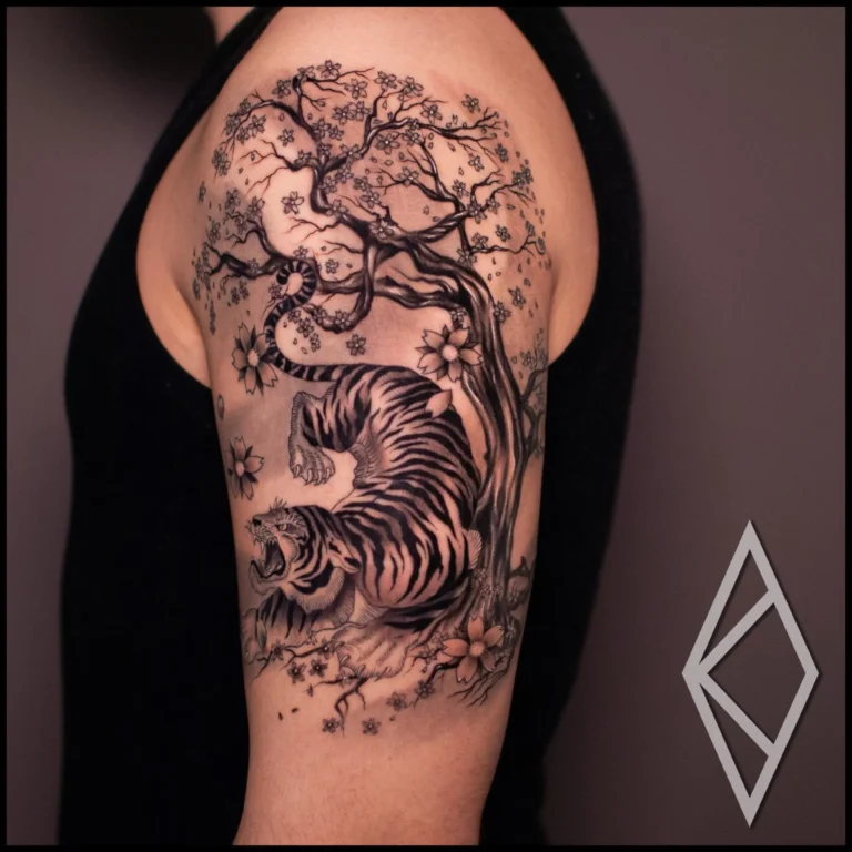 Japanese tiger and sakura tree tattoo on upper arm