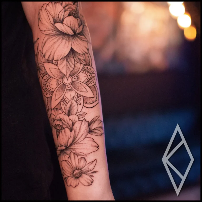 Fineline tattoo on forearm, beautiful flowers and mandala in the center