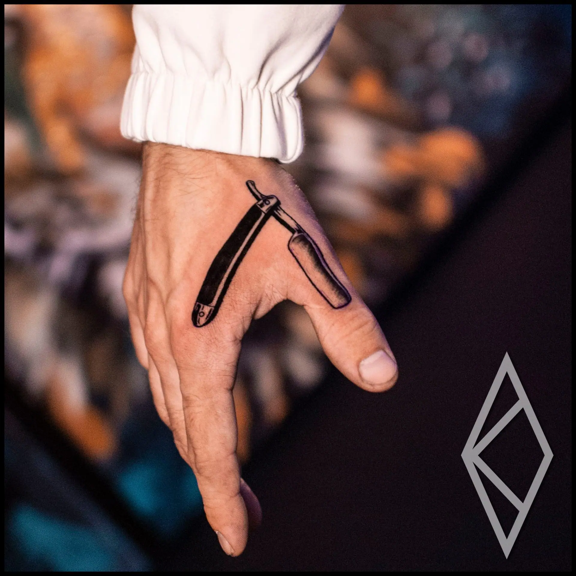 Tattoo of barber blade on hand, bold and crisp